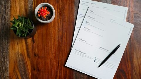 Printed forms and a pen laid out on a wooden table