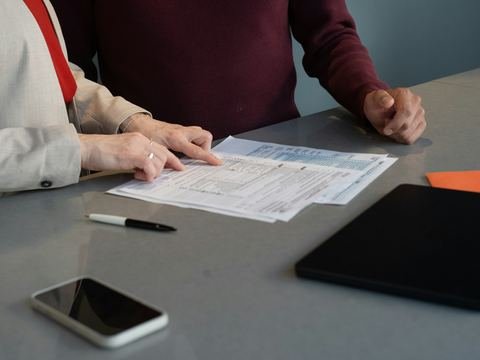 Two people reviewing documents together at an office table